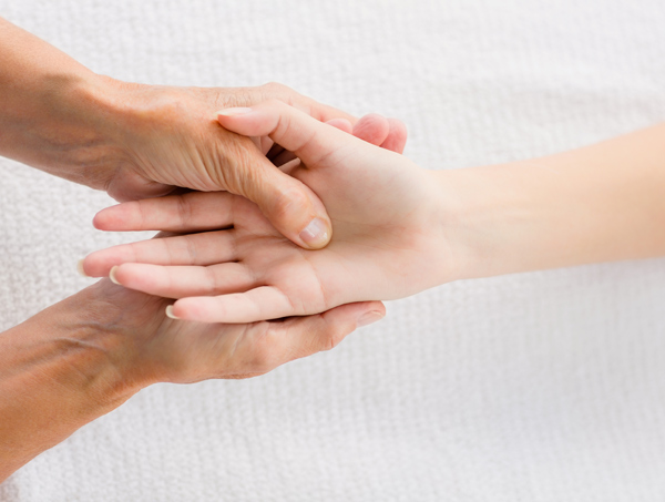 two hands clasped together on a soft surface illustrating connection and support showcasing seven layers of care and interaction